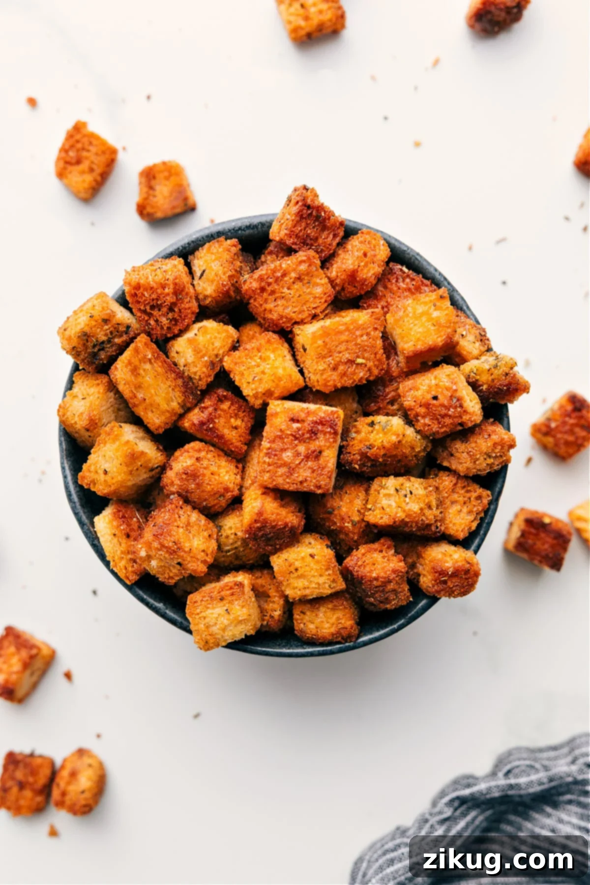 A bowl overflowing with golden-brown homemade croutons, perfectly toasted and seasoned, ready to be devoured.