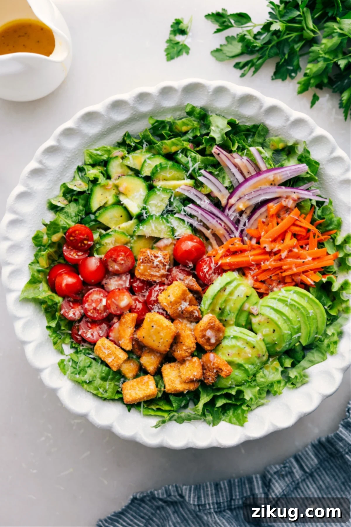 A vibrant, freshly prepared garden salad in a large, inviting bowl, showcasing crisp lettuce, colorful cherry tomatoes, sliced cucumbers, and grated carrots.