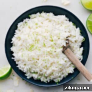 A close-up of a bowl of creamy, fluffy coconut rice topped with fresh lime zest, showcasing its inviting texture and vibrant garnish. It is ready to be served and enjoyed.