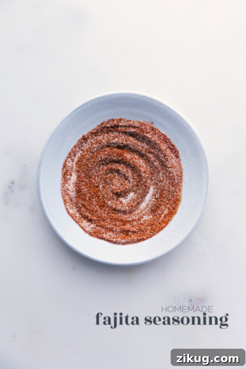 Our favorite Homemade Fajita Seasoning blend is incredibly simple to make, utilizing common spices you likely already have in your pantry! Bypass the store-bought packets; you'll never want to revert once you experience the ease and superior taste of preparing your own seasoning blends. This recipe elevates your chicken fajitas to a new level of deliciousness. #homemade #mexican #fajita #seasoning #mix #chickenfajitas #easyrecipe Overhead image of a vibrant homemade fajita seasoning mix in a bowl
