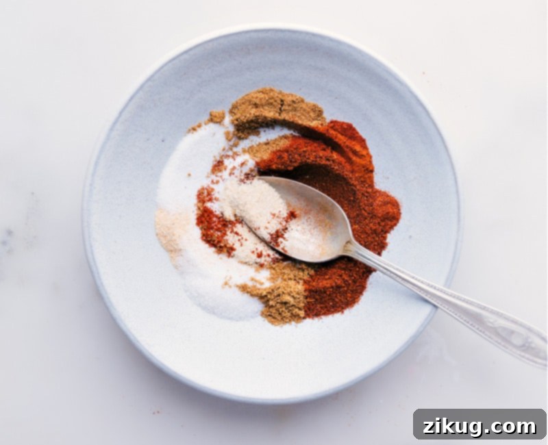 Our favorite Fajita Seasoning blend is incredibly simple to make, utilizing common spices you likely already have in your pantry! Bypass the store-bought packets; you'll never want to revert once you experience the ease and superior taste of preparing your own seasoning blends. This recipe elevates your chicken fajitas to a new level of deliciousness. #homemade #mexican #fajita #seasoning #mix #chickenfajitas #easyrecipe Process shot of the Fajita Seasoning blend—image of the seasonings being mixed together in a bowl with a whisk