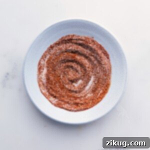 Close-up of homemade chicken fajita seasoning in a small bowl, garnished with whole spices.