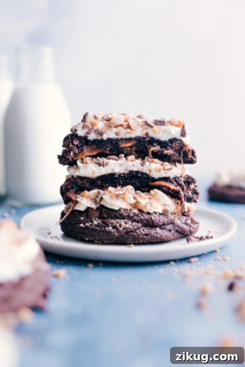 Heath Bar Cookies: The ultimate chocolate-lover's dream. Gooey, caramel-filled chocolate cookies topped with whipped cream frosting and crunchy toffee bits. A true 'Better Than Anything' cookie experience. #dessert #best #quick #easy #simple #frosting #candybar #caramel #heathbar #cookies Stack of luscious Heath Bar Cookies, generously frosted and topped with toffee bits, inviting a bite