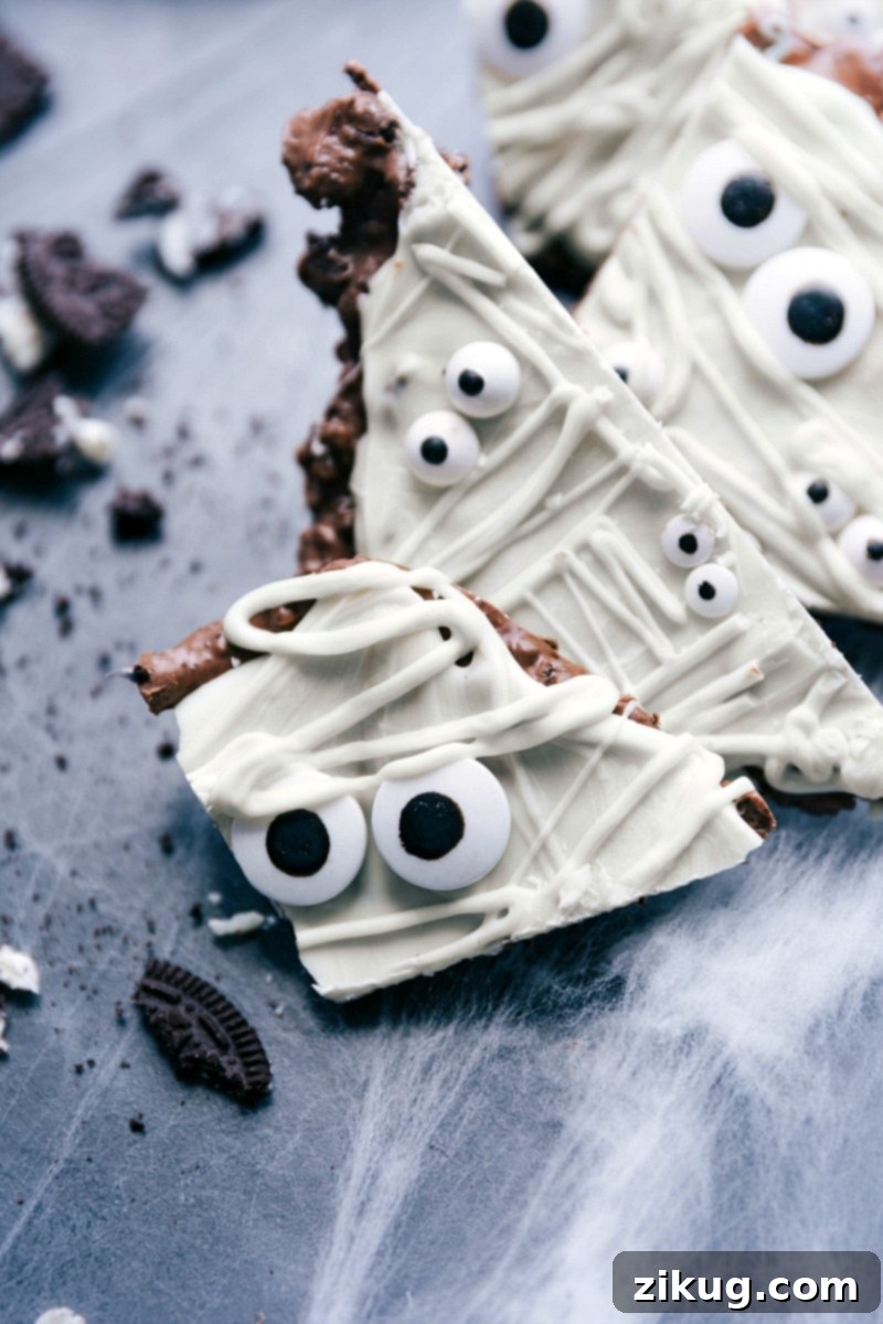 A few slices of the delicious and chocolatey Halloween inspired dessert, which is easy and perfect for any spooky occasion! The mummy bark is broken into irregular pieces, showcasing the contrasting layers of dark and white chocolate with candy eyes.
