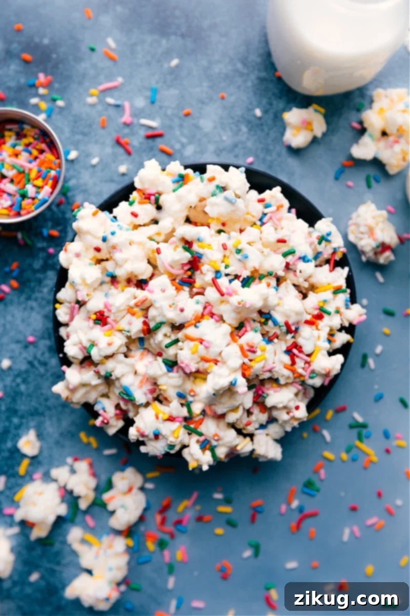 Cake Batter Popcorn - sweet, crunchy, and loaded with sprinkles. Features popcorn tossed in melted white chocolate and actual cake mix for an authentic cake batter flavor experience.