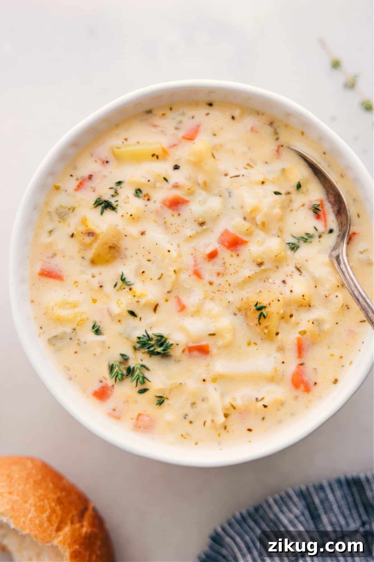 Hearty And Delicious Cauliflower Soup: A Comforting Winter Meal Idea A steaming bowl of creamy cauliflower soup, garnished with fresh thyme leaves, sits on a rustic wooden table.