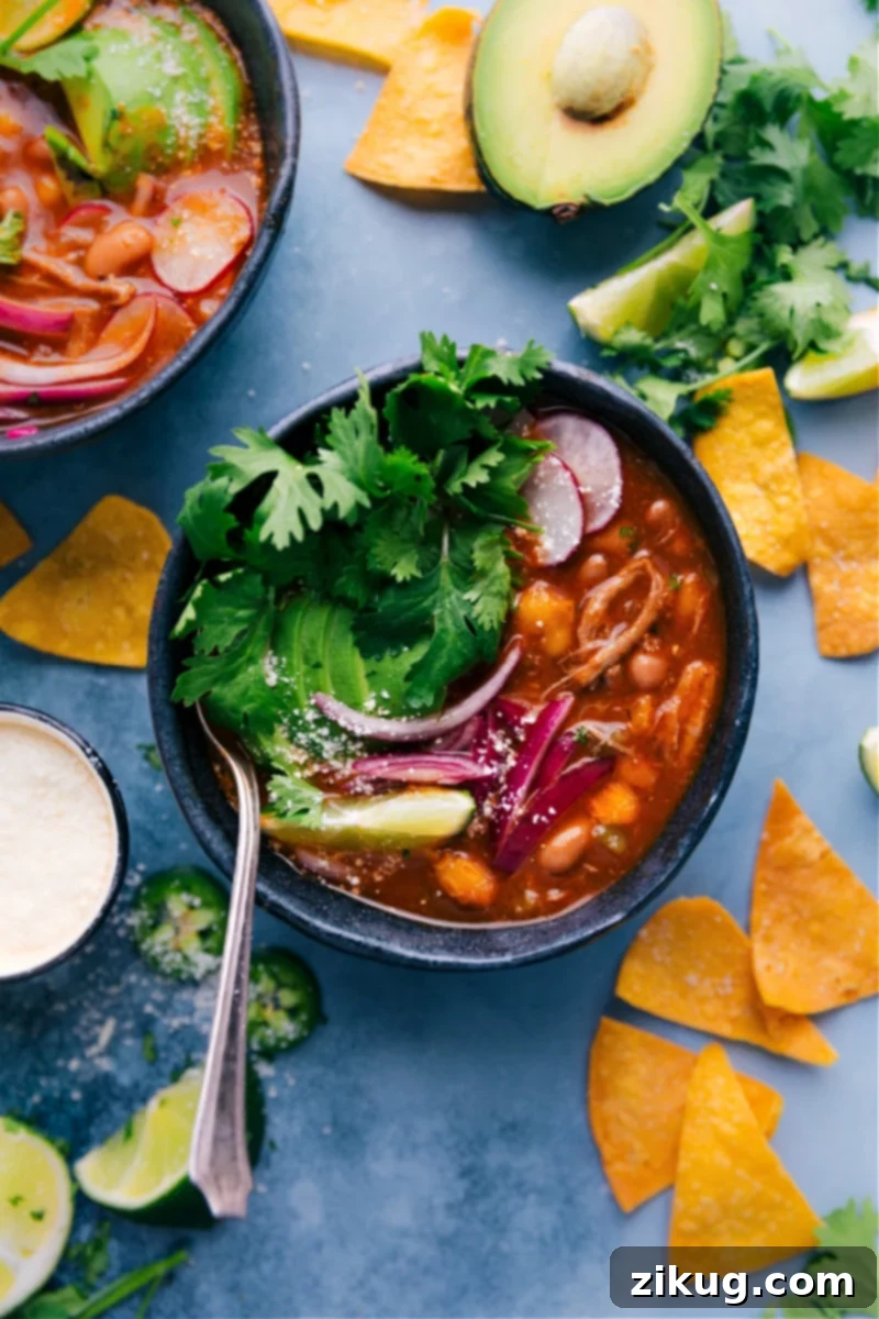 Quick 30-Minute Pozole Recipe with Hominy & Pulled Pork Overhead image of a vibrant bowl of Quick Pozole garnished with fresh toppings like avocado, cilantro, and lime.