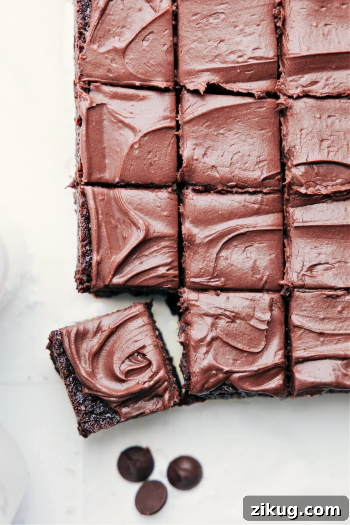 Healthy Brownies sliced and stacked, generously topped with rich chocolate frosting, highlighting their dense and fudgy texture.