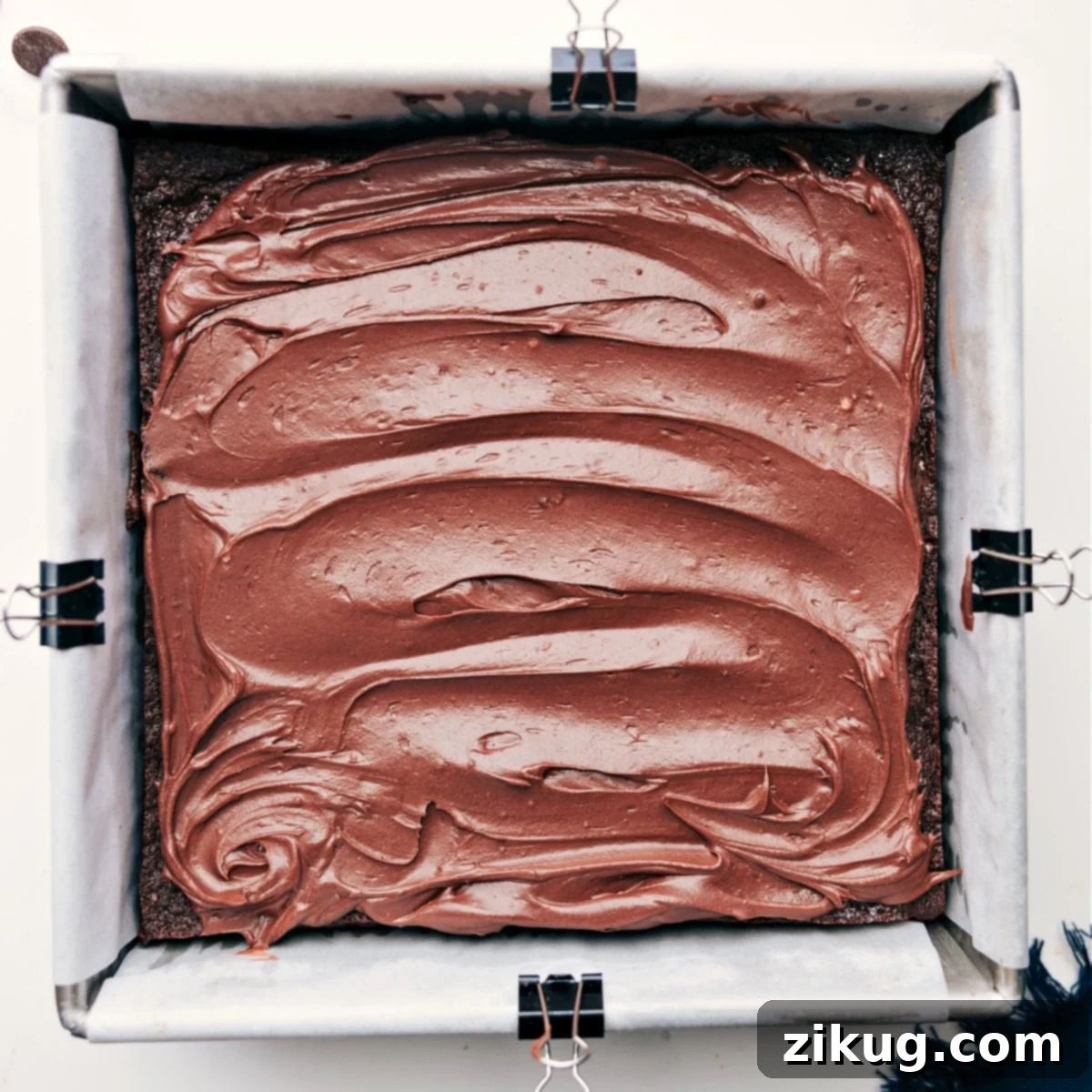 A generous, smooth layer of delectable ganache-like frosting spread perfectly over the healthy brownies.