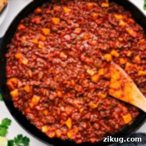 A delicious bowl of Mexican Picadillo with tortillas and lime wedges.