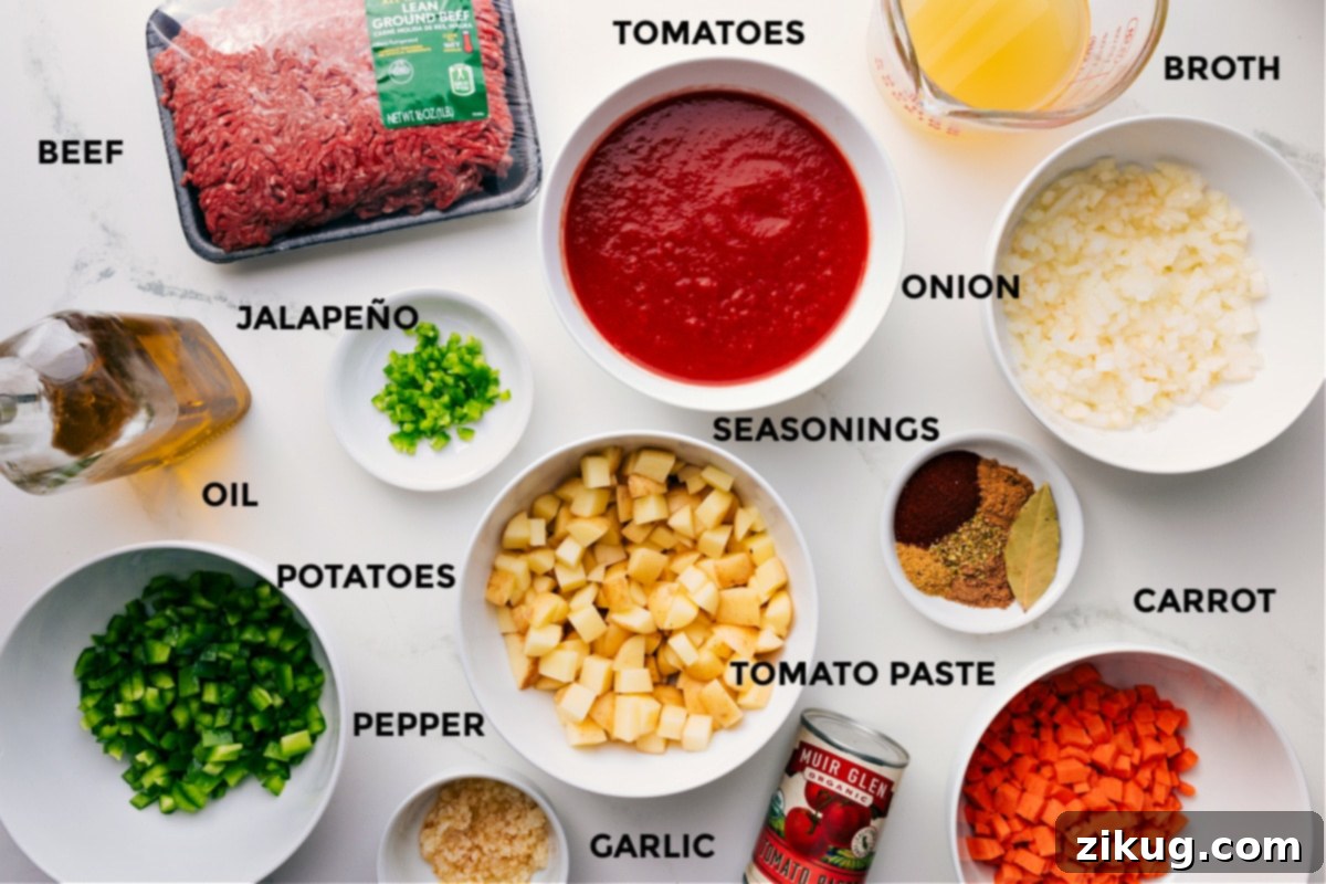 Key Ingredients In Mexican Picadillo Recipe All the fresh ingredients for this Mexican Picadillo recipe prepped and ready for easy assembly, including lean ground beef, robust beef broth, ripe tomatoes, diced onions, a selection of vibrant seasonings, sweet carrots, rich tomato paste, tender potatoes, a hint of spicy jalapeño, olive oil, cracked black pepper, and minced garlic.