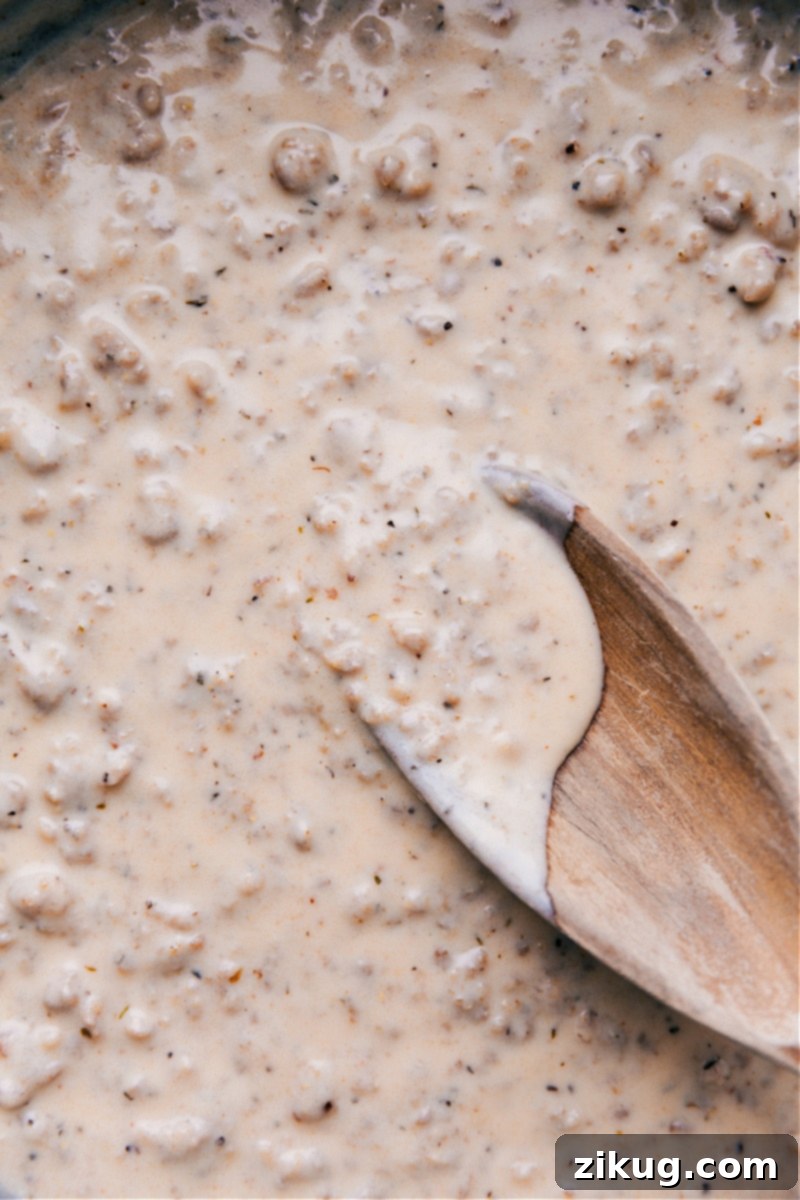 Overhead view of rich, creamy sausage gravy simmering in a pan, ready to be served.