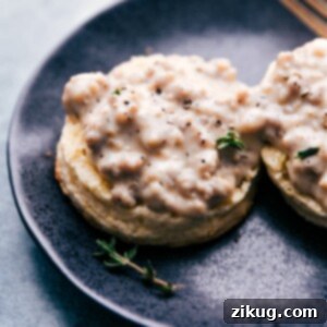 A bowl of creamy sausage gravy next to a stack of biscuits.