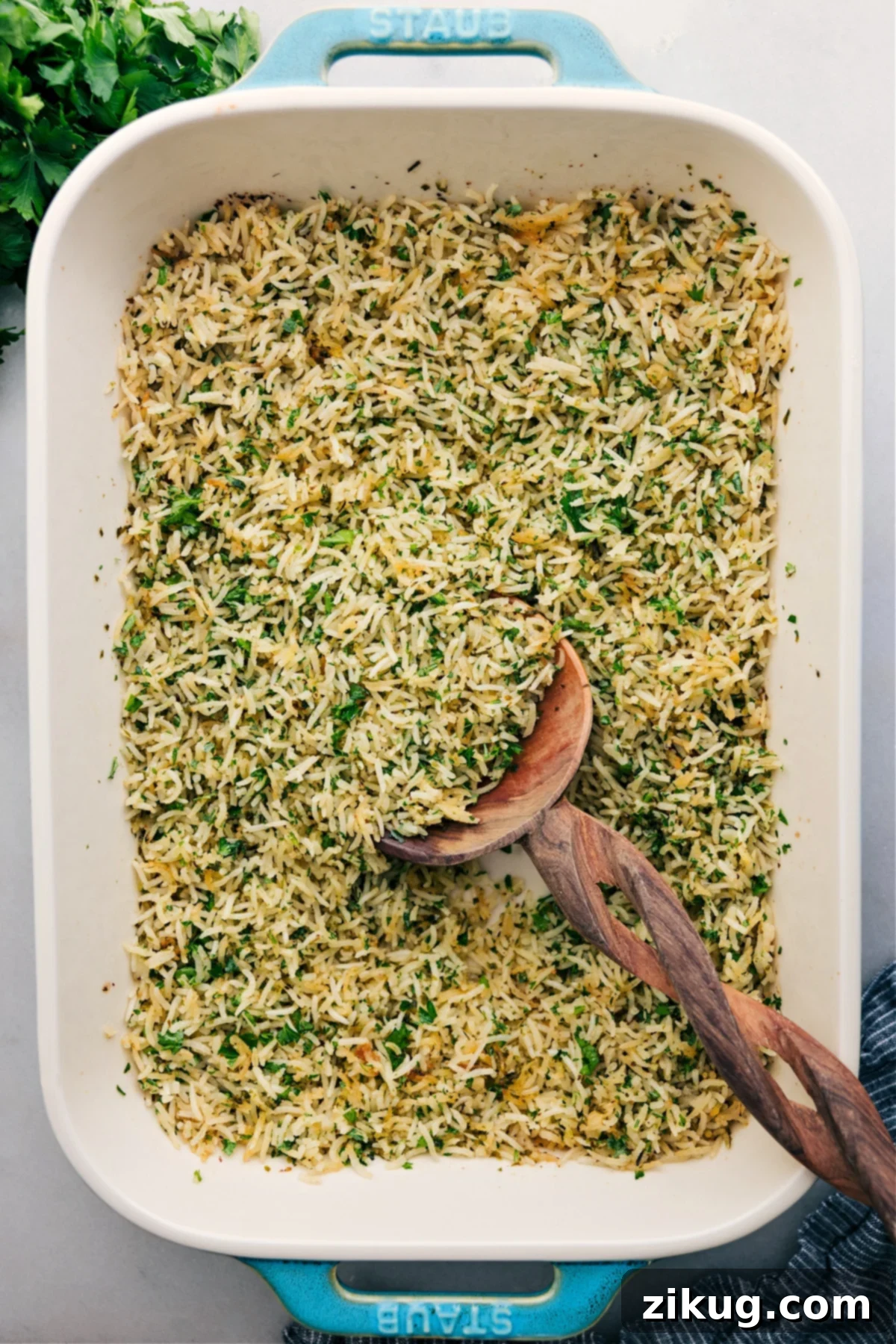 The Best One-Pan Baked Herb Rice Recipe Herb Rice cooked in a single casserole dish, with a big scoop served up.