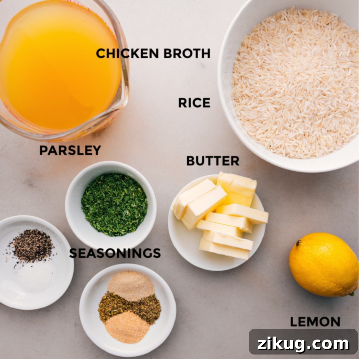 Essential Ingredients for Flavorful Herb Rice All the ingredients for this recipe are prepped for easy assembly: chicken broth, seasonings, butter, rice, lemon, and fresh parsley.
