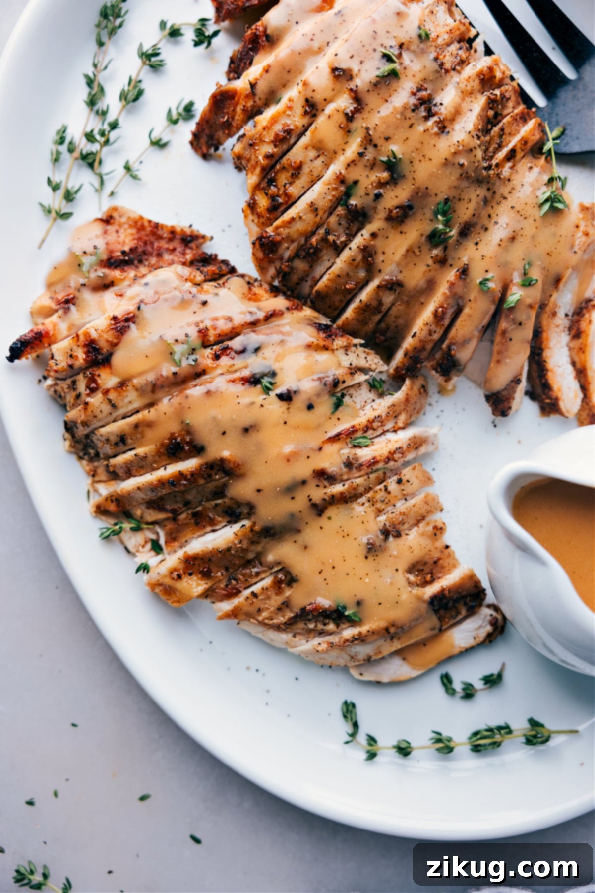 A perfectly cooked turkey breast, generously coated in rich, savory gravy, beautifully presented on a dinner plate, showcasing its golden-brown skin and succulent slices, ready for a delightful meal.