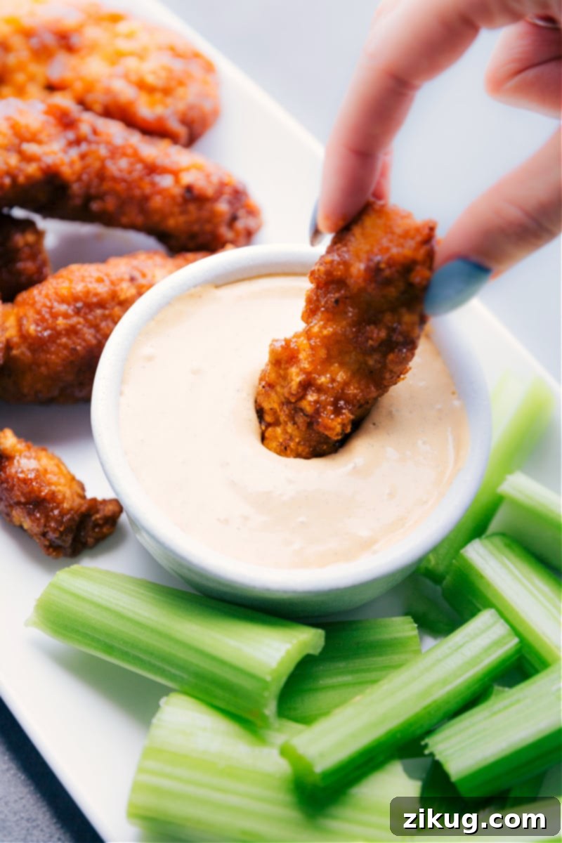 Image of a piece of crispy chicken being dipped into the creamy Chipotle Ranch Dip