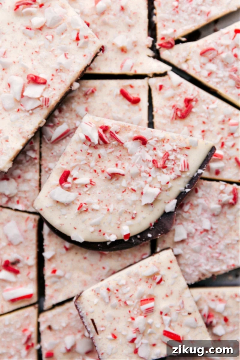The ultimate homemade Peppermint Bark recipe, featuring three luxurious types of chocolate and vibrant crushed peppermint. Perfect for Christmas and holiday desserts. Overhead image of homemade Peppermint Bark glistening with crushed peppermint on a serving tray, ready for holiday celebrations.