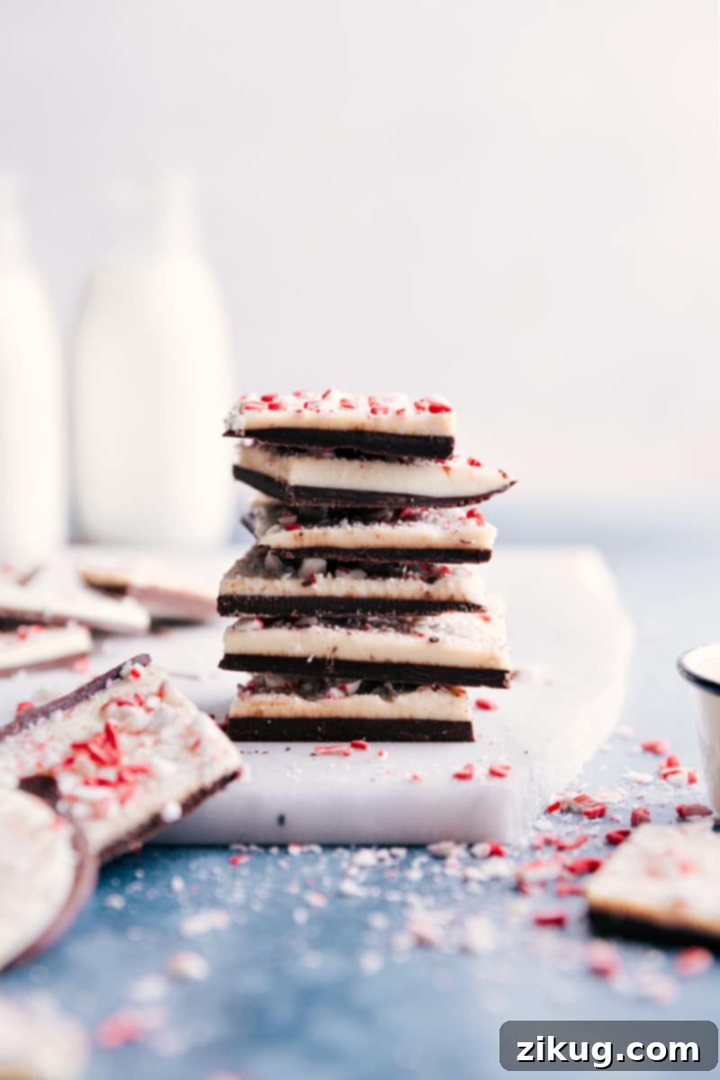Beautifully stacked homemade Peppermint Bark, showcasing perfect layers and festive peppermint, ideal for holiday sharing. Stack of freshly made Peppermint Bark pieces, showing the distinct layers of chocolate and the festive crushed peppermint topping, ready for gifting or serving.