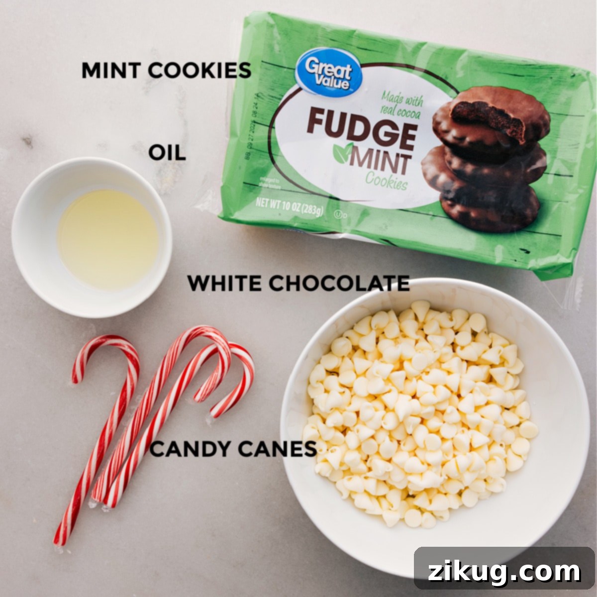 The four key ingredients for these easy Peppermint Cookies are neatly arranged and ready for use: a package of mint fudge cookies, white chocolate melting wafers, coconut oil, and vibrant candy canes.