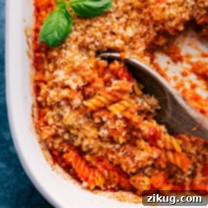 A beautifully baked dish of One-Pan Chicken Parmesan Pasta, garnished with fresh basil leaves.