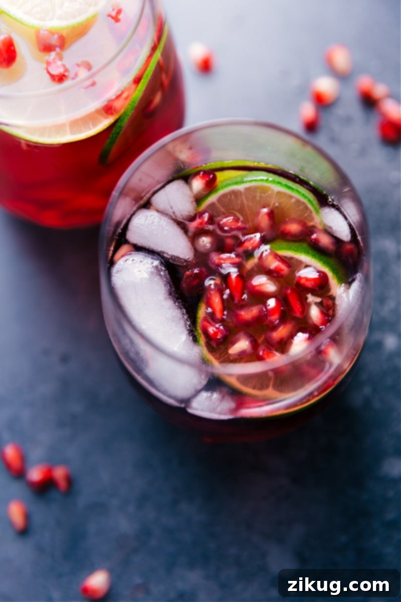 A refreshing glass of Sparkling Pomegranate Juice garnished with fresh pomegranate arils and lime slices, ready to be enjoyed.