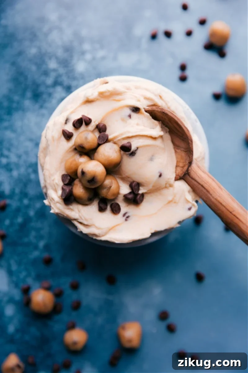Delicious Cookie Dough Frosting featuring rich vanilla buttercream and chunks of edible cookie dough. Overhead image of creamy Cookie Dough Frosting swirled on a plate