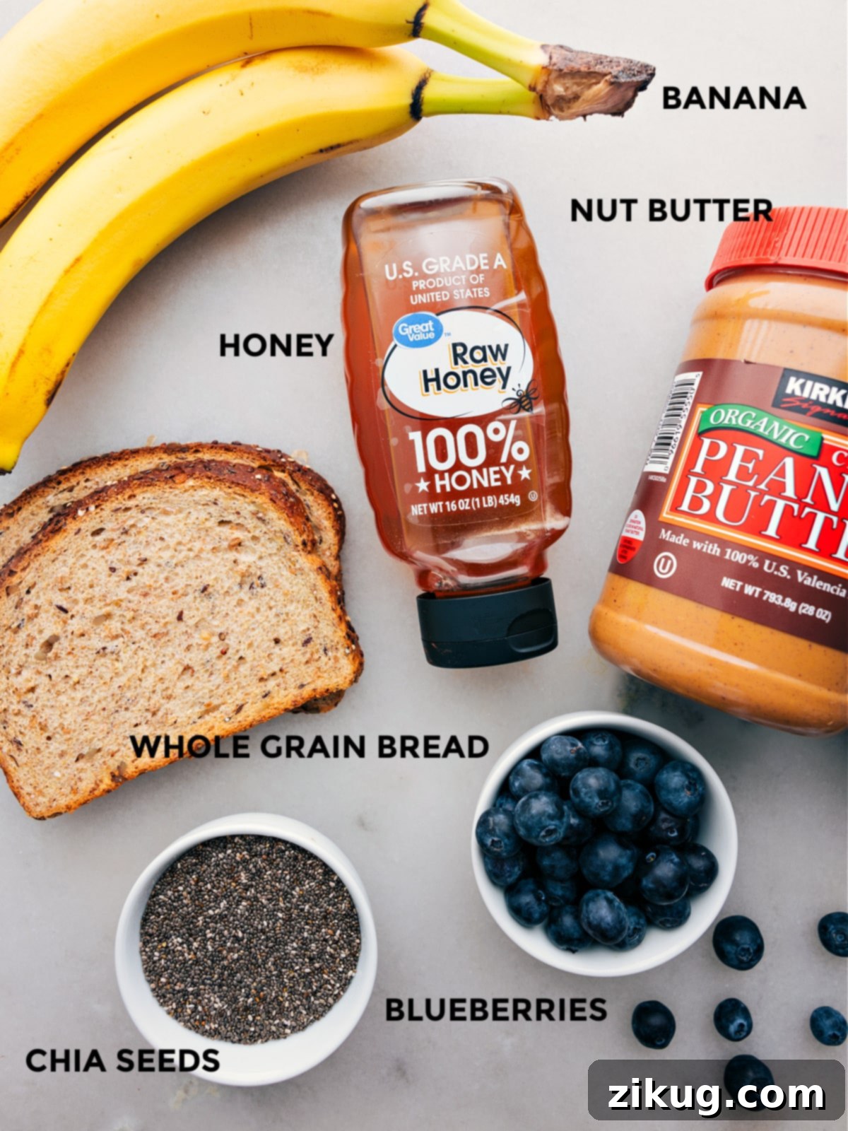 All the vibrant ingredients for healthy breakfast toast laid out on a table: ripe banana, creamy nut butter, golden honey, slices of whole-grain bread, fresh blueberries, and a sprinkle of chia seeds, all prepped for effortless assembly.