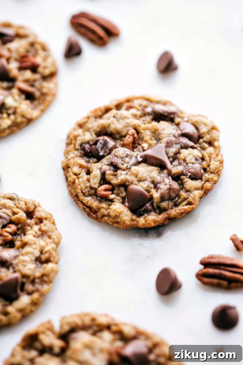 The finished dessert, a tray of freshly baked oatmeal pecan cookies, full of delicious and complementary flavors, ready to be enjoyed right out of the oven. Some have extra chocolate chips and sea salt on top.