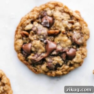 Freshly baked and delicious oatmeal pecan cookie with melted chocolate chips on top, a sprinkle of fresh sea salt, and baked pecans.