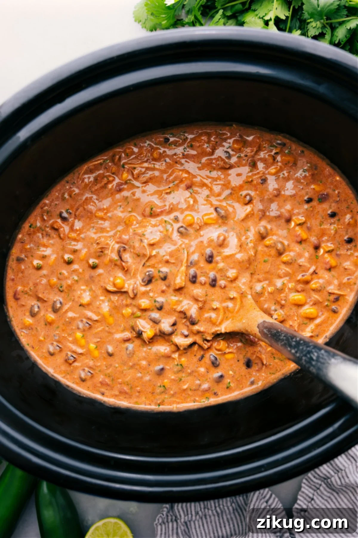 The Best Creamy Slow Cooker Chicken Chili Recipe Delicious creamy chicken chili served in a bowl, garnished with fresh cilantro and a dollop of sour cream, perfect for a cozy meal.