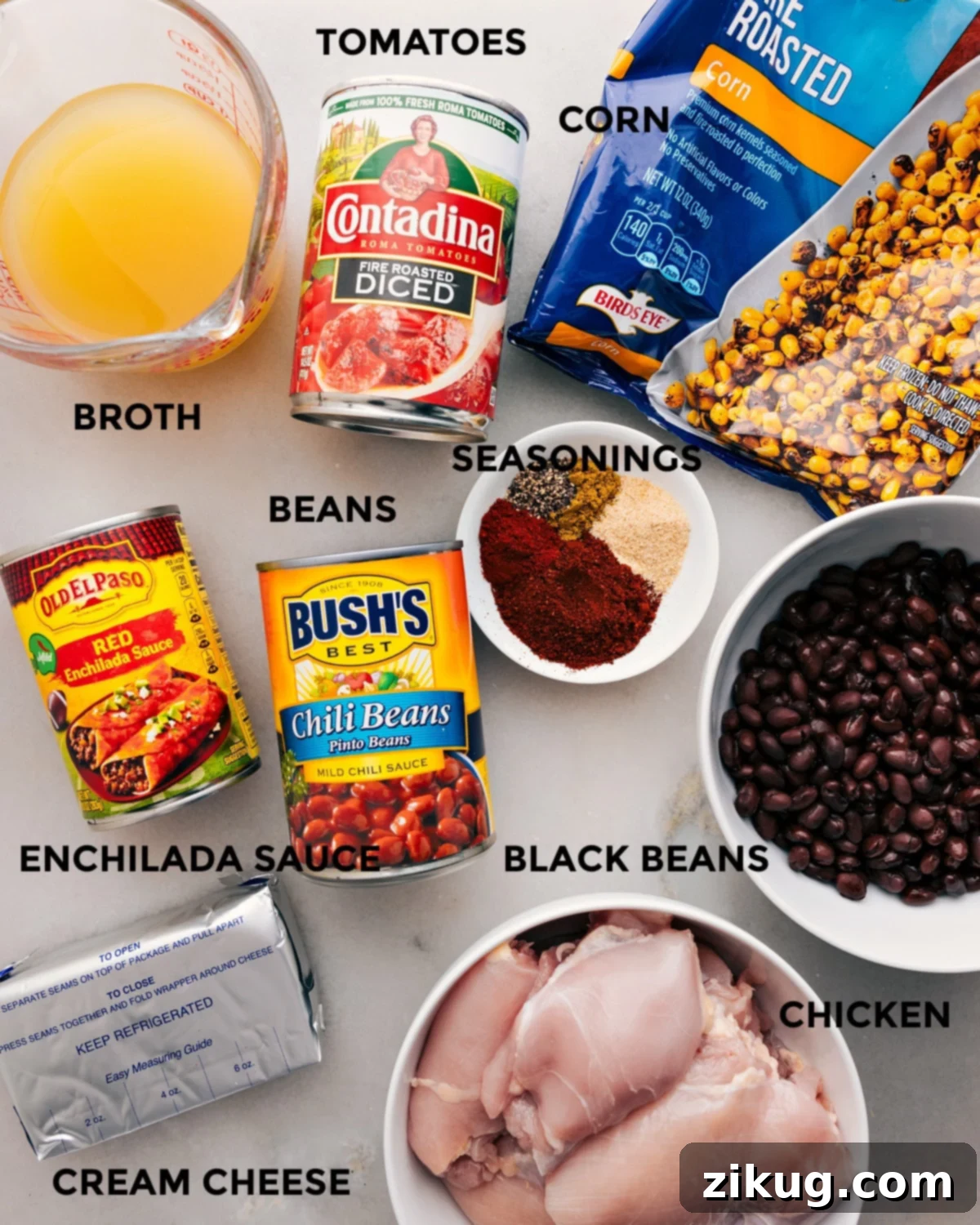 Key Ingredients for Making Homemade Crockpot Chicken Chili All the essential ingredients for slow cooker creamy chicken chili laid out: red enchilada sauce, diced tomatoes, chili beans, black beans, frozen corn, boneless chicken, chicken stock, cream cheese, and various seasonings.