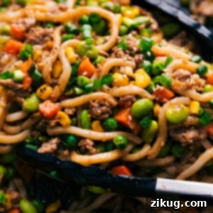 A bowl of freshly prepared Easy Udon Stir Fry, garnished and ready to be served.