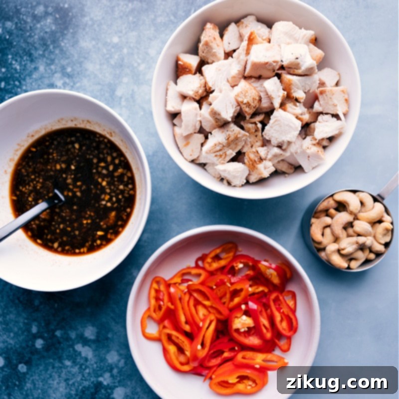 Ingredients to Make Cashew Chicken All the fresh and pantry ingredients for Cashew Chicken laid out, including chicken, cashews, sliced red peppers, and the sauce components.