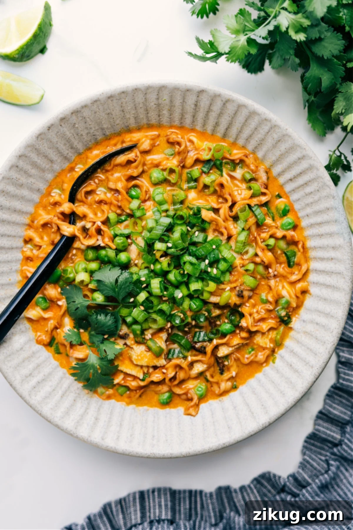 Quick & Easy Red Curry Noodle Soup with Chicken A vibrant bowl of Curry Noodle Soup, featuring tender chicken, ramen noodles, and bright green peas in a rich coconut-curry broth. Garnished with fresh cilantro and lime.