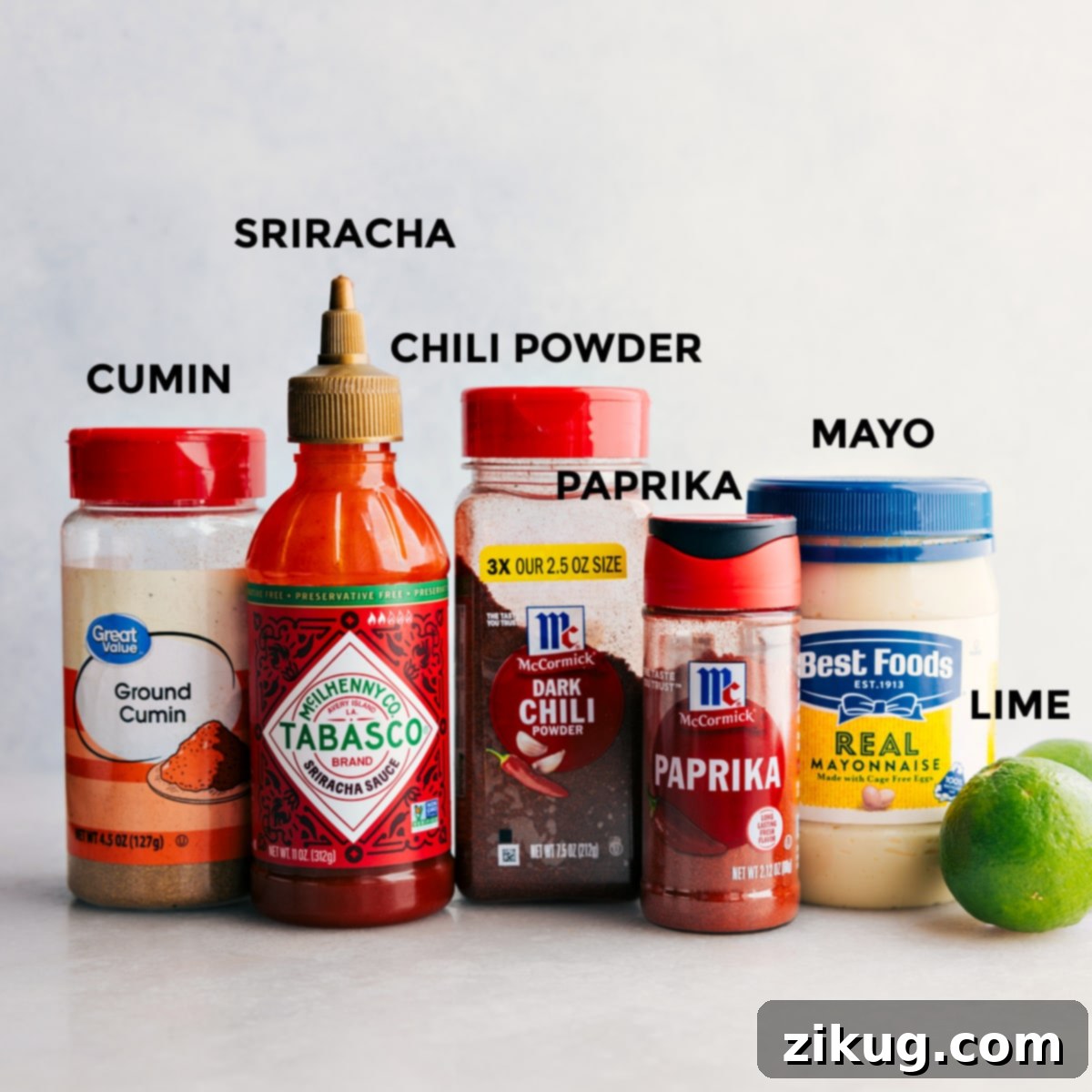 All the dressing ingredients including cumin, sriracha, chili powder, paprika, mayo, and limes prepped out for easy assembly.