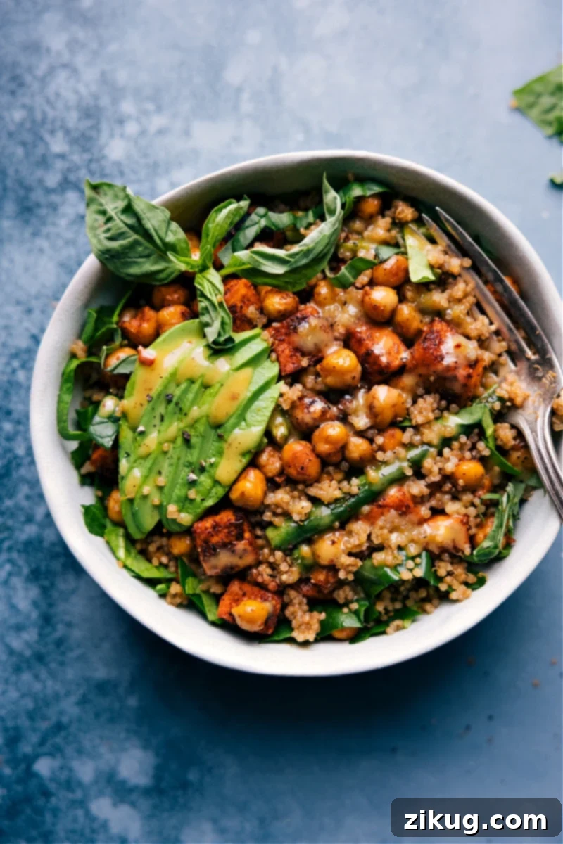 Beautifully arranged overhead shot of a colorful Nourish Bowl with roasted sweet potatoes, green beans, chickpeas, quinoa, and a drizzle of hot honey mustard sauce