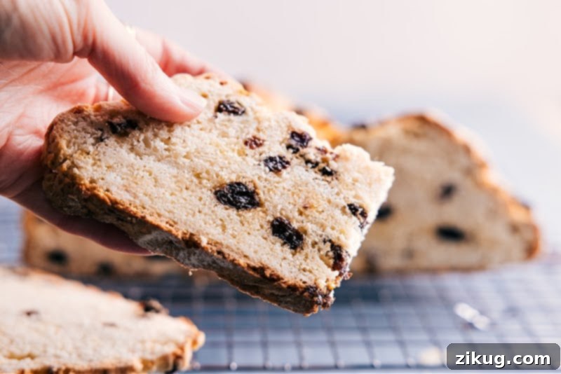 A perfectly sliced piece of Irish Soda Bread, ready to be enjoyed with butter or jam, showing its tender crumb.
