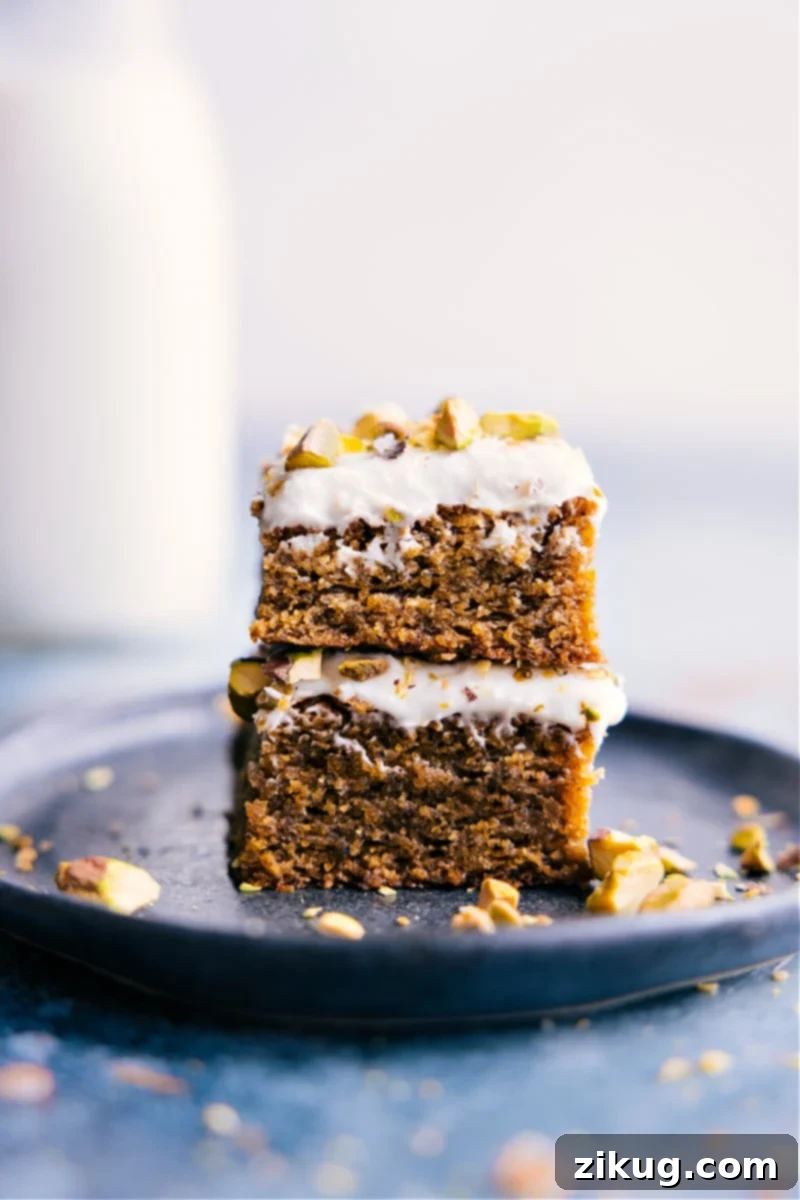 The Ultimate Pistachio Cake: Sweet, Moist, Dense, and Gluten-Free with Cream Cheese Frosting - a truly healthy and family-friendly dessert from ChelseasMessyApron. Stacked slices of a moist and delicious Pistachio Cake, showcasing its vibrant green color and creamy frosting.