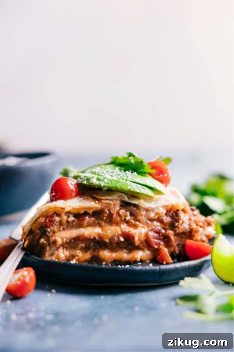 Delicious Taco Tortilla Pie recipe with layers of beef, beans, salsa, and cheese. Perfect for an easy family dinner! #tortillapie #tacopie #easydinner #familyfriendly #mexicanfood #casserole Image of Tortilla Pie on a plate, garnished with fresh toppings