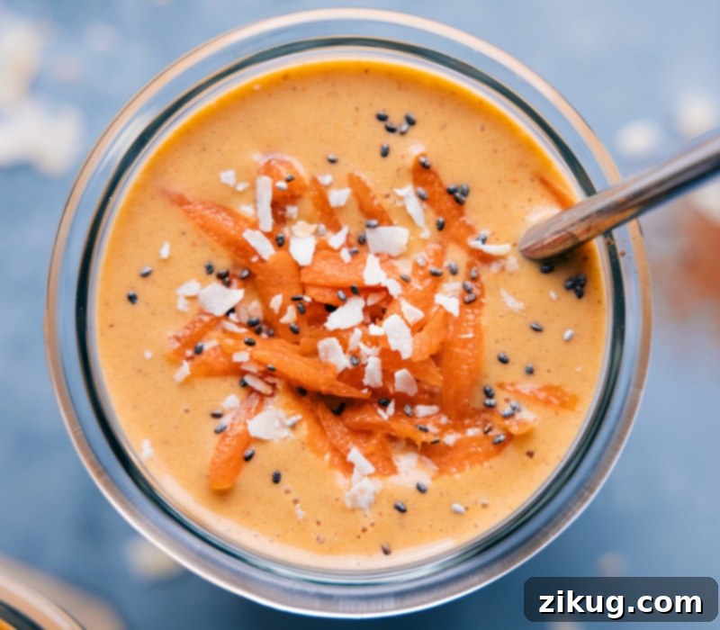 Sunshine Carrot Blend 2 A tall glass of a creamy, orange Carrot Smoothie, garnished with a sprinkle of cinnamon and a fresh mint leaf. The texture appears thick and inviting.