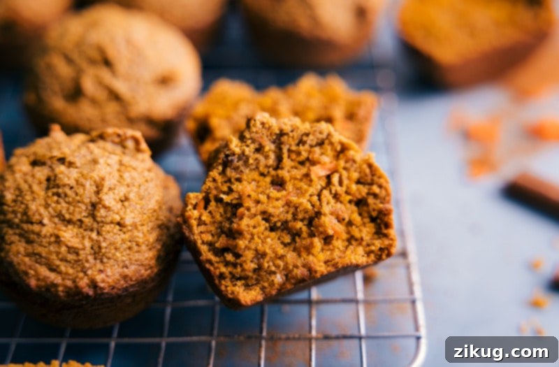 Enjoy these Healthy Carrot Muffins, a nutritious and flavorful snack made with wholesome ingredients, dairy-free, gluten-free, and refined sugar-free. Image of the Healthy Carrot Muffins with one muffin cut in half to show its moist interior and carrot flecks.