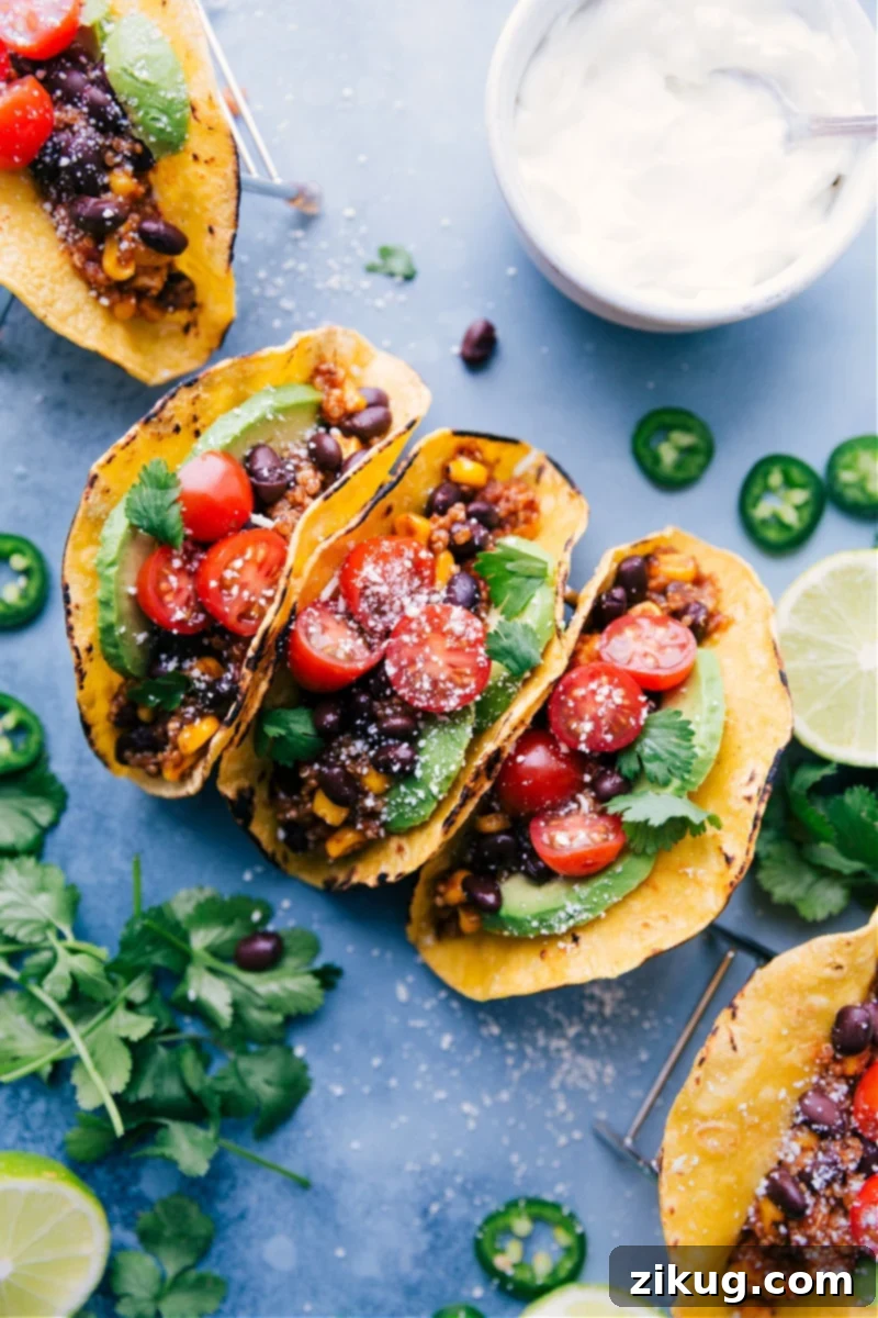 Flavor-packed, meatless Quinoa Tacos are incredibly easy; just dump everything into the slow cooker and let it work its magic! Serve on warmed tortillas with your favorite taco toppings. Recipe via chelseasmessyapron #dinner #quick #easy #simple #delicious #healthy #vegetarian #quinoa #tacos Overhead image of beautifully arranged Slow Cooker Quinoa Tacos with fresh toppings.