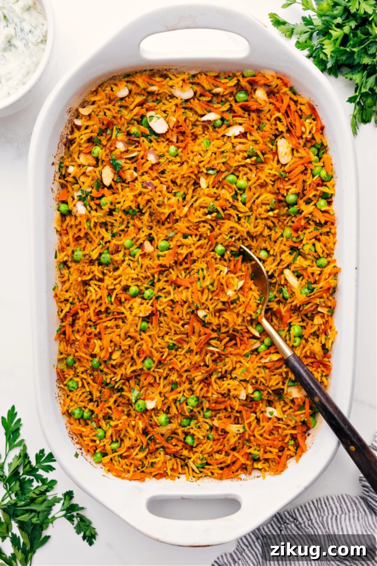 Mind Blowing Easy One Pan Curry Rice Curry Rice in a baking dish with a spoon serving a portion.