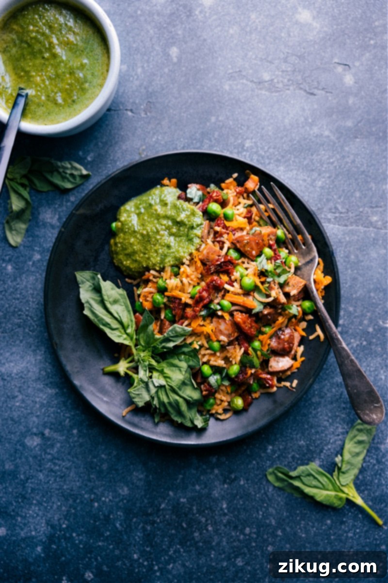 A serving of One-Pan Pesto Rice in a bowl, with a small dish of extra basil pesto on the side, ready for individual customization.