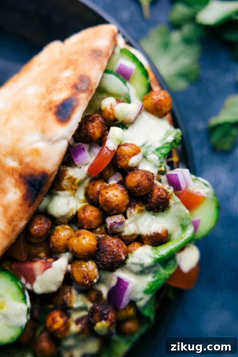Vegetarian Tikka Masala Wraps: Soft pita, Indian-spiced chickpeas, crunchy veggies, and the best cilantro-mint sauce for a healthy, quick, and easy dinner. Recipe via ChelseasMessyApron #dinner #quick #easy #healthy #whole #wholeingredients #clean #cleaneating #tikka #masala #wraps Overhead image of the Tikka Masala Wraps, showcasing the vibrant colors and fresh ingredients ready to be enjoyed.