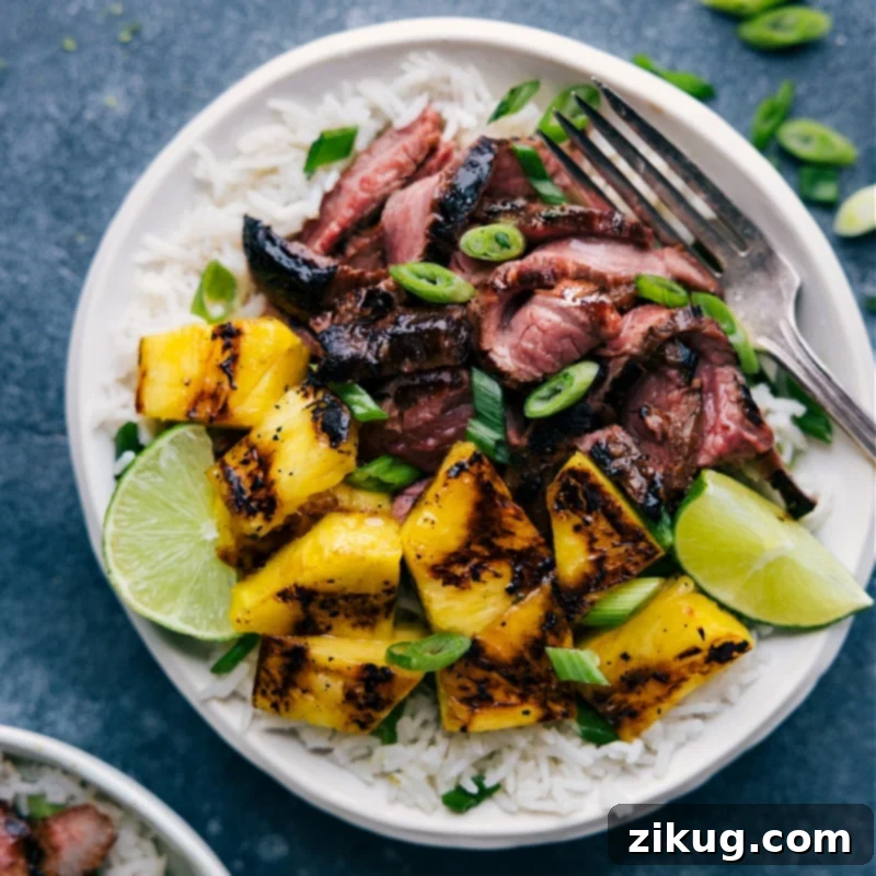 Overhead image of the finished Pineapple Steak dish, beautifully plated with coconut-lime rice, sliced steak, and grilled pineapple chunks, ready to be enjoyed.