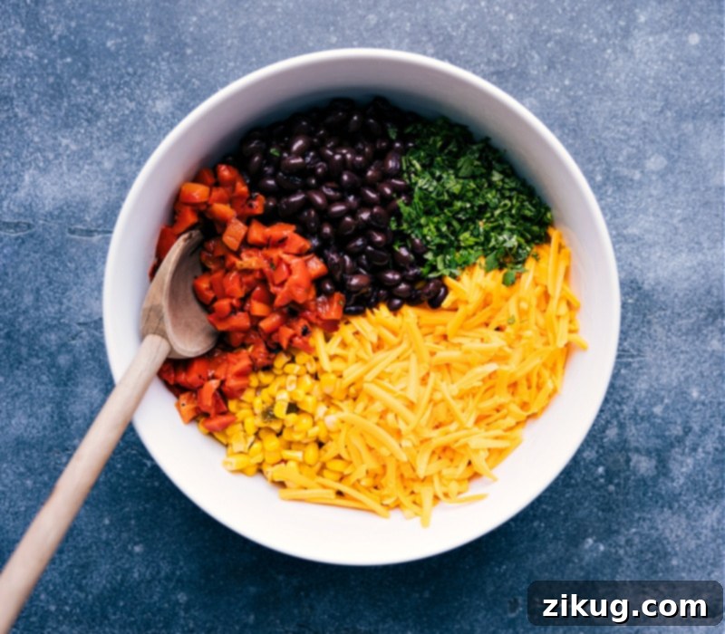 Essential Ingredients for Black Bean Quesadillas in a Bowl A large bowl filled with key ingredients for black bean quesadillas: roasted red peppers, black beans, corn, shredded Cheddar cheese, and fresh cilantro, ready to be mixed.