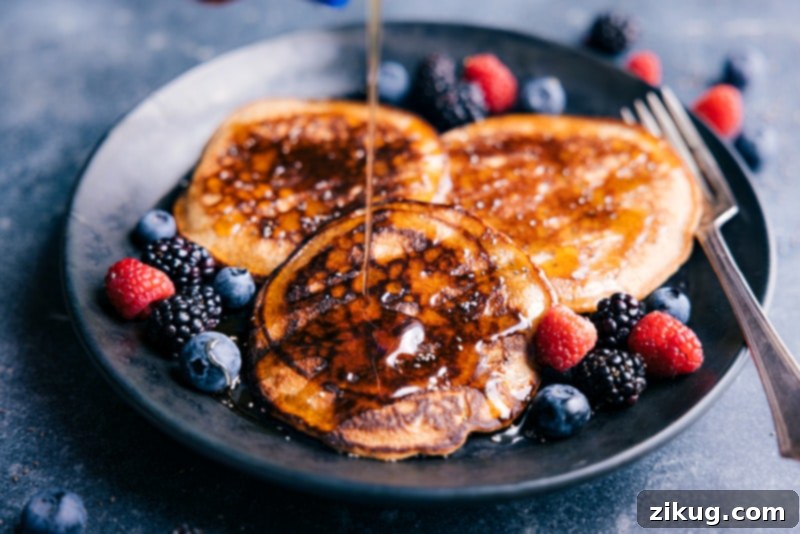These Healthy Pancakes have a wonderful crisp exterior with perfectly soft & chewy interiors. They're made with better-for-you ingredients without sacrificing texture or flavor! And did we mention they are ridiculously easy to make? Throw everything into a blender and give it a whirl! Recipe via ChelseasMessyApron #breakfast #quick #easy #simple #dessert #cleaningredients #familyfriendly #kidfriendly #brunch #healthy #pancakes Image of healthy pancakes drizzled with golden maple syrup, ready to be served.