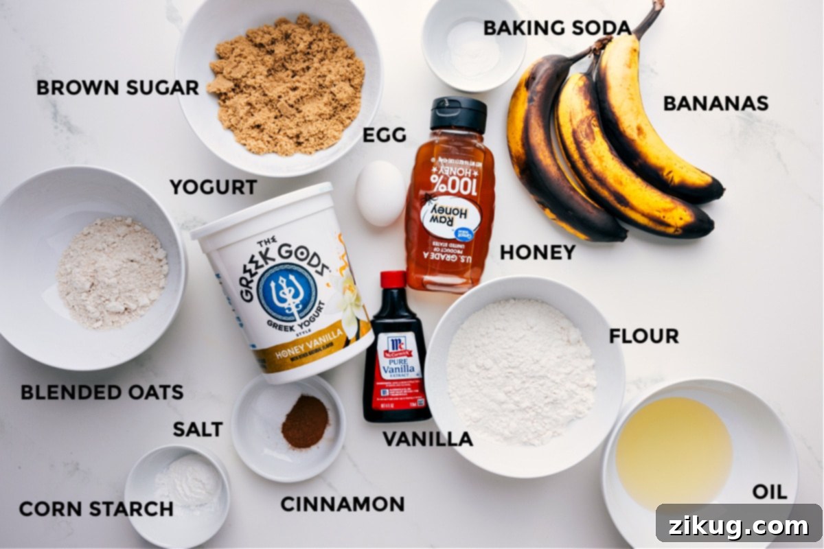 Ingredients In Greek Yogurt Banana Bread All the essential ingredients for making Greek yogurt banana bread, neatly arranged for preparation, including very ripe bananas, vanilla Greek yogurt, eggs, brown sugar, honey, melted coconut oil, various flours, and spices.